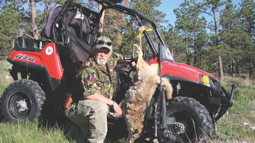 The author with a Black Hills coyote taken by way of Savage 6.5 Creedmoor while using high ground over long dry wash below. (Kill shot 397 ranged yards.)
