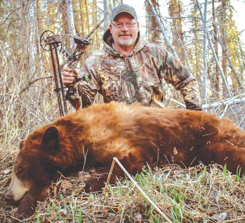 The author with his first cinnamon-colored black bear, which turned out to be the smaller of two color-phase bears hitting the same bait.