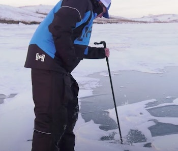 Jason Mitchell checks early ice thickness and quality with a spud bar.