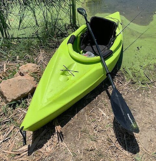 The author sets a thin seat cushion in the kayak, then places his turkey vest, which has a built-in back support, over the cushion.