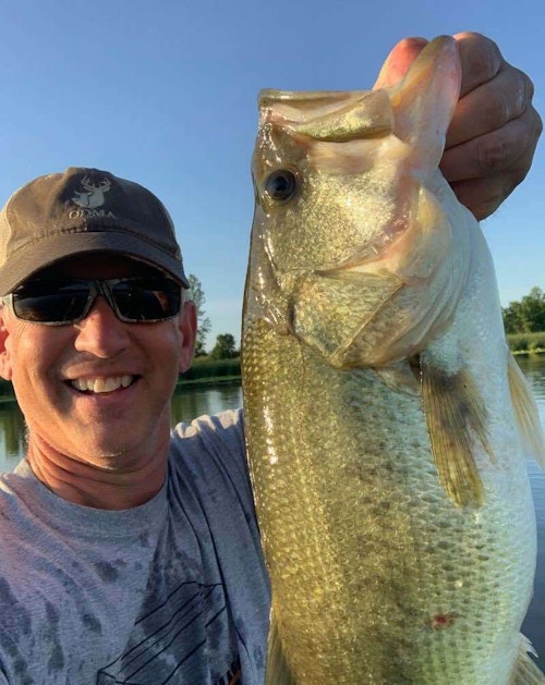 It’s never easy taking selfies in a kayak, especially while holding a decent-sized bass. Here, the author does his best to capture his on-the-water field test success. 