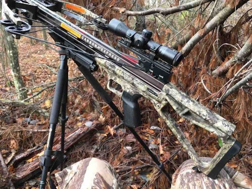 When waiting on a whitetail, the author rests the front of his crossbow on a tripod yoke, and the back on his knee. This allows him to keep both hands free.