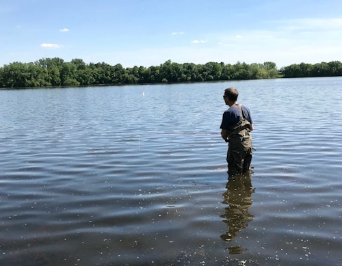 The author fly casting for spawning sunfish on a warm May afternoon. He wore breathable waders with jeans underneath to avoid overheating.