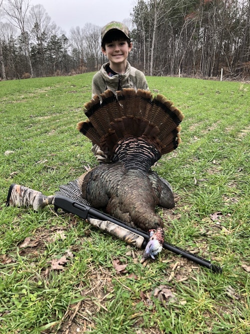 The writer's son pictured with his first wild turkey, taken using a Remington 870 Express Compact in 20 gauge. The writer chose the Apex LT-20 round with 1 3/8 ounces of #8 TSS in a 2 ¾ inch shell. Photo: Mark Olis